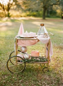 brass bar cart with pink christmas hot cocoa and cake