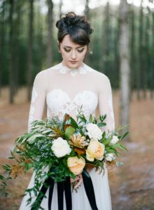 sultry bride with thick bang and organic loose bouquet with black ribbon