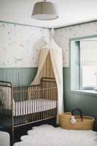 nursery with wallpaper and green paneling
